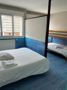 敦刻尔克Hôte de la Plage的一间卧室设有两张双层床,铺有蓝色地板。