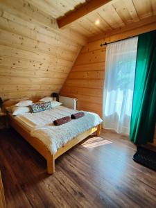 乔乔洛U Dziadka的木制客房内的一间卧室,配有一张床