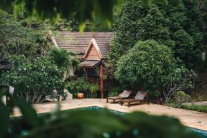 象岛Kooncharaburi Resort - Koh Chang的一个带两把椅子的游泳池和一个树屋