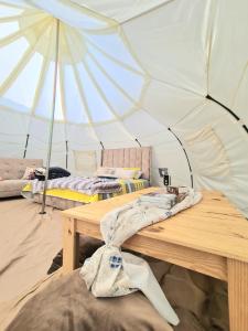 基多Hermoso Glamping en Quinta Privada的帐篷配有两张床和一张木桌