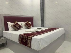 孟买Hotel Sai Plaza, Chembur Mumbai的一张带白色床单和枕头的床