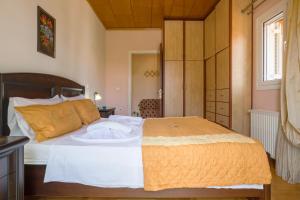 Skoulikádhonsparrow apartment (Σπουργιτης)的一间卧室配有一张带白色床单和橙色毯子的床。