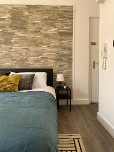 布莱克浦Seaside Suite 1 - Beautiful Long Stay Studio on Lord Street的一间卧室设有一张床和砖墙