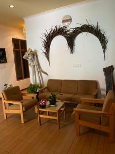 图鲁斯杜Ocean Cottage Maldives的客厅配有沙发、椅子和雕像