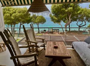 罗萨斯Almadrava Paradise的客厅配有桌椅,享有海景。
