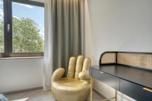 拉纳goldfinger + suites的客房设有椅子、书桌和窗户