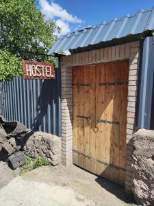博尔若米ATI MTA - Eco Hostel的木车库,带有木门和标志