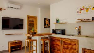 吉汶瓦CDM Villas Kiwengwa的一个带柜台的厨房和墙上的电视