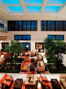 北京北京金融街丽思卡尔顿酒店的大型大堂配有沙发、桌子和树木