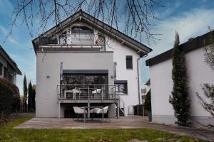 埃佩尔海姆Design Apartment in Eppelheim的带阳台和两把椅子的白色房屋