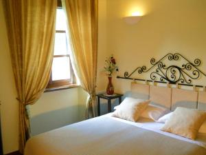 迪亚诺达尔巴卡拉比纳乡村民宿的一间卧室配有一张带白色床单的床和一扇窗户。