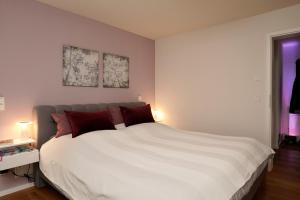 埃佩尔海姆Design Apartment in Eppelheim的卧室配有带红色枕头的大型白色床