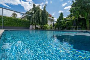 拉纳goldfinger + suites的一座房子前面的蓝色海水游泳池