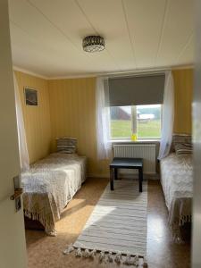 GamlebyPatterdale farm holiday apartments的客房设有两张床、一个窗户和一个地毯。