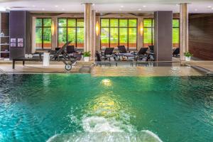 穆劳附近圣格奥尔根克里斯赫伯格休闲度假酒店的游泳池位于带桌椅的房间中间