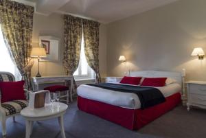 阿拉斯Hôtel de L'univers的一间卧室配有一张带红色枕头的大床