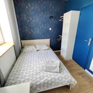布雷斯特Chambre Crozon avec salle de bains privative dans une résidence avec salon et cuisine partagés的一张小床,位于一个蓝色的墙壁内