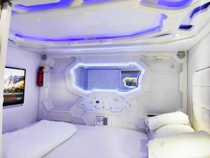 曼谷Met A Space Pod @Phrom Phong的白色的客房配有床和电视。