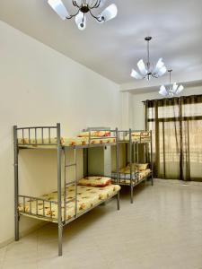 迪拜Robin Hostel Dubai的带天花板的客房内的三张双层床
