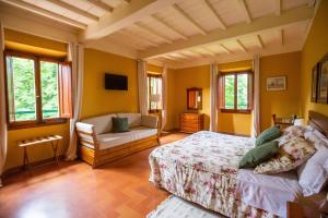 基安蒂格雷夫Albergo Villa San Michele的一间卧室配有一张床、一张沙发和窗户。