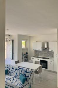 马达莱纳Appartamento Tizzy的厨房以及带桌子和沙发的用餐室。