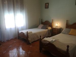 安特克拉CASA RURAL EL CHAPARRO的一间卧室设有两张单人床和一个窗户。