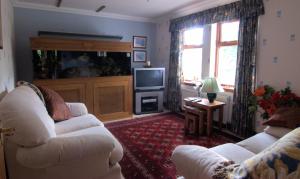 缪勒夫奥德家庭农场食宿酒店的客厅配有2张白色沙发和1台电视