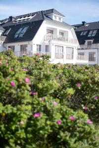 韦斯特兰DAS LORNSEN - Serviced Luxury Apartments的前面有粉红色花的白色房子