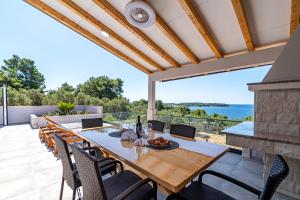 尼亚卢卡Villa Blue Panorama的海景天井上的餐桌和椅子