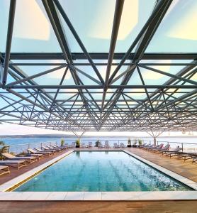茨里克韦尼察奥莫瑞卡酒店的一个带椅子的游泳池,背景是大海