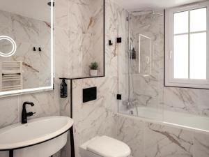 巴黎Solly Hôtel Paris的带淋浴和盥洗盆的白色浴室