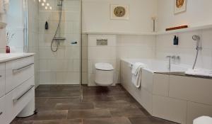 格罗斯滕本尼克卡尔德酒店的带淋浴、浴缸和卫生间的浴室