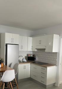 弗龙特拉Las Vistas的厨房配有白色橱柜和白色冰箱。