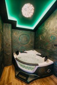 吉格涅斯科斐耶Villa Sunset Pool & Spa apartments的天花板客房内的大浴缸
