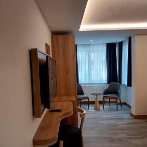 安卡拉Dab Hotel Ulus的配有电视和桌椅的酒店客房