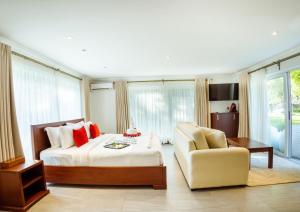 迪亚尼海滩Searenity Beach Villa的一间大卧室,配有一张床和一把椅子