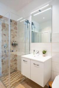 茨维考FeelgooD Apartments DELUXE Zwickau CityCenter mit TG-Stellplatz, Netflix und Waipu-TV的浴室配有白色水槽和淋浴。