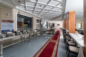 Ghdar DeflaTanger Med Hotel, Conference & Catering的一间带桌椅的用餐室和一间自助餐厅