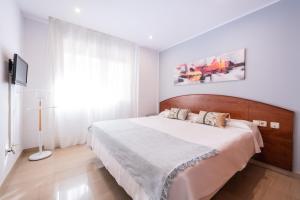 巴塞罗那拿波尔斯公寓式酒店的一间卧室配有一张大床和木制床头板