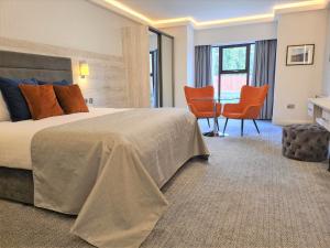 多尼戈尔米尔公园酒店的酒店客房带一张床、一张桌子和椅子