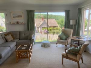 DaleColdstream Cottage的带沙发和椅子的客厅以及大窗户。