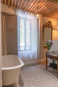 AmpusAuberge des braconniers的带浴缸和窗户的浴室