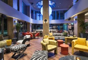 利马索尔NYX Hotel Limassol by Leonardo Hotels的大堂设有色彩缤纷的桌椅