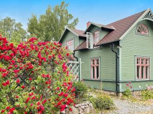 龙讷比Holiday home RONNEBY X的前面有红花的绿色房子