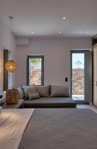 帕罗斯岛Clementina Paros的带沙发和2扇窗户的客厅