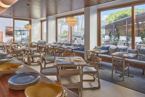 圣埃乌拉利亚特雷斯托雷斯酒店的餐厅设有桌椅和窗户。
