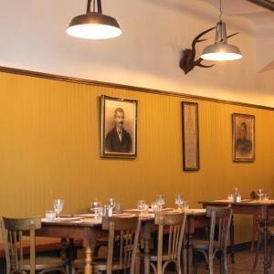 AmpusAuberge des braconniers的配有木桌和人肖像的用餐室