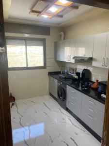 丹吉尔Appart Hicham的厨房配有白色橱柜、洗衣机和烘干机