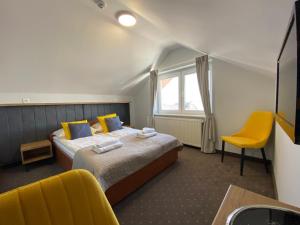 库瑞尼卡慕斯卡克雷尼察酒店的酒店客房,配有床和黄色椅子