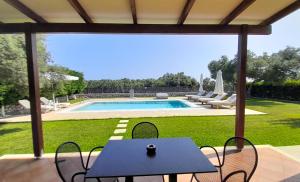 苏卡雷斯Lefkogea Villas & Apartments的一个带桌椅的庭院和一个游泳池